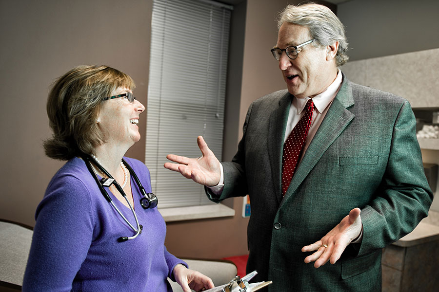 Two people have a discussion in a doctor's office.