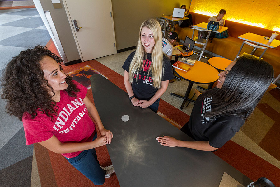 An overhead shot of 3 students in IU gear standing at a table.