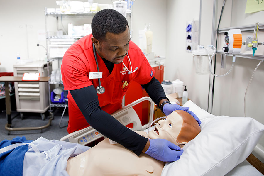 An IUSB student examines a simulation lab dummy.