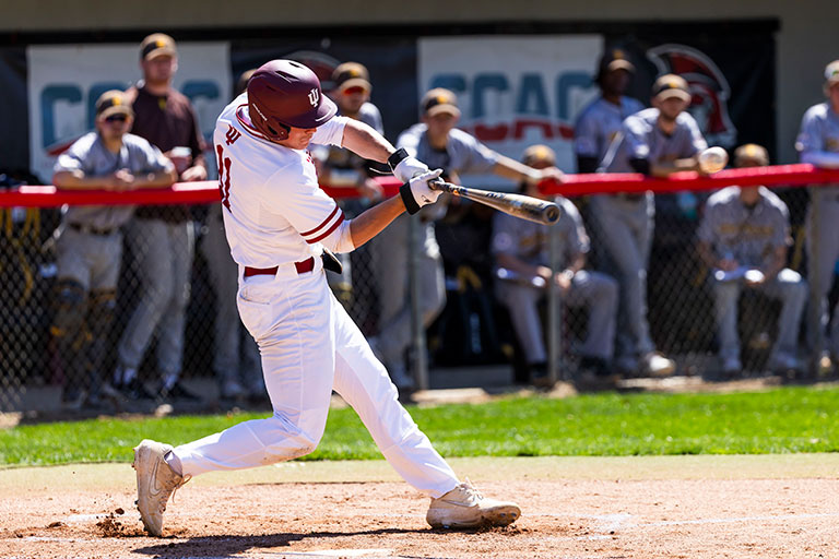A Titans baseball player swings his bat at home plate.