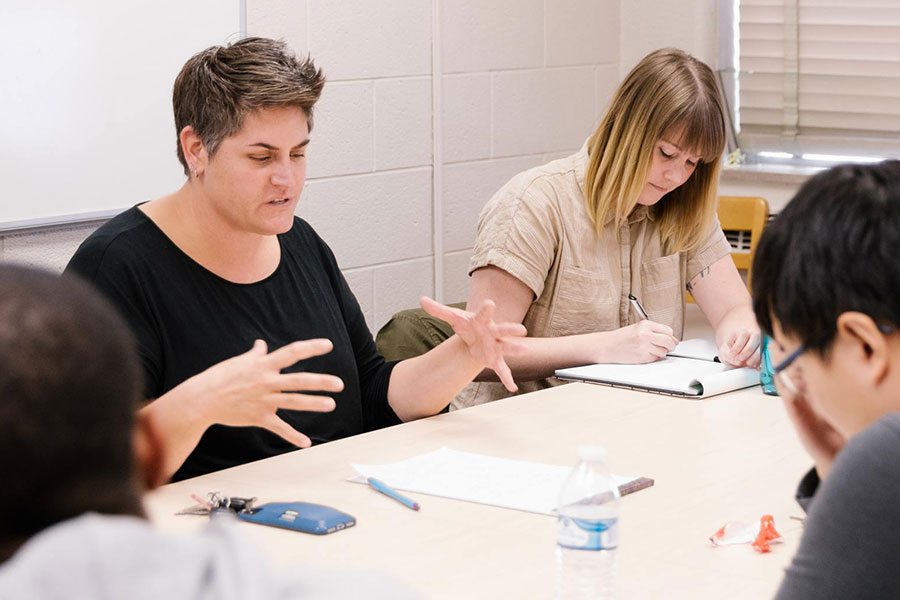 A group of graduate students has a discussion at a table.
