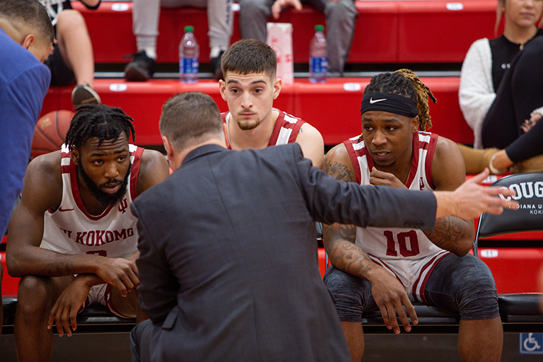 A coach talks to his IU Kokomo men's basketball team on the sidelines.