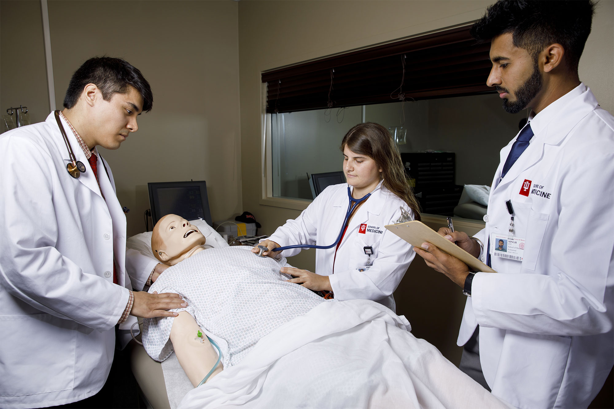 Medical students working on a medical mannequin.