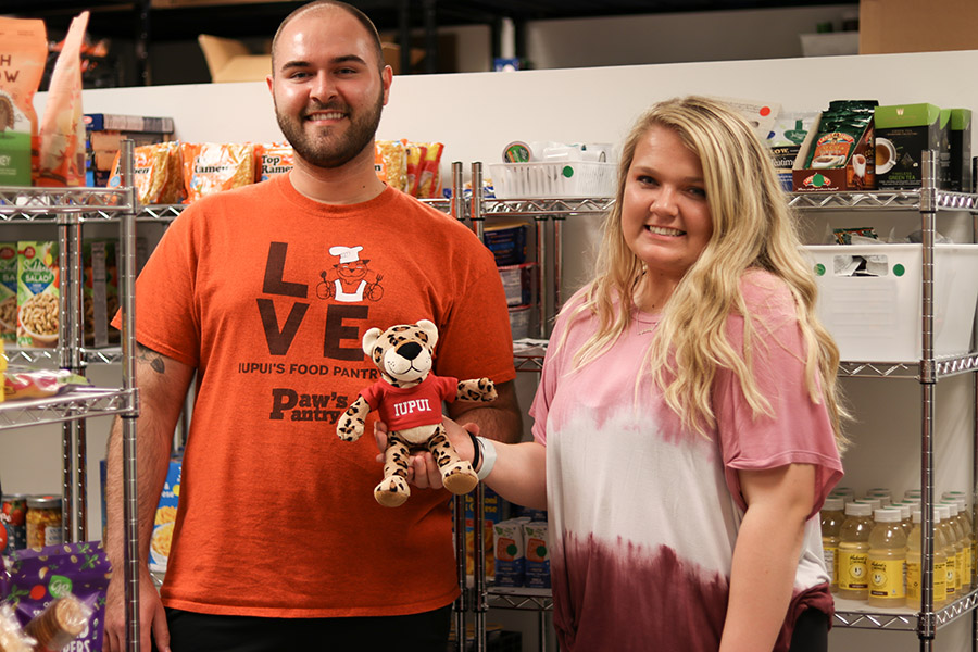 Two volunteers pose in the pantry with a Jaws plushie.