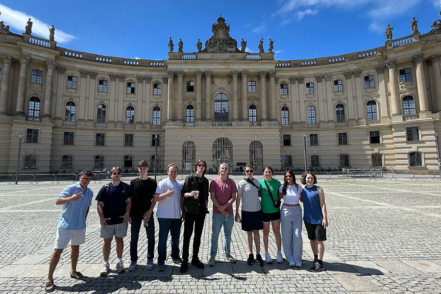 A group of students stands in front of a historical building in Berlin.