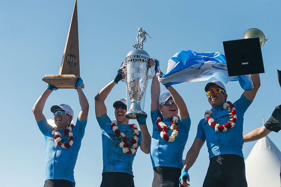 A Phi Delta Theta Little 500 team celebrates on the podium while holding trophies.