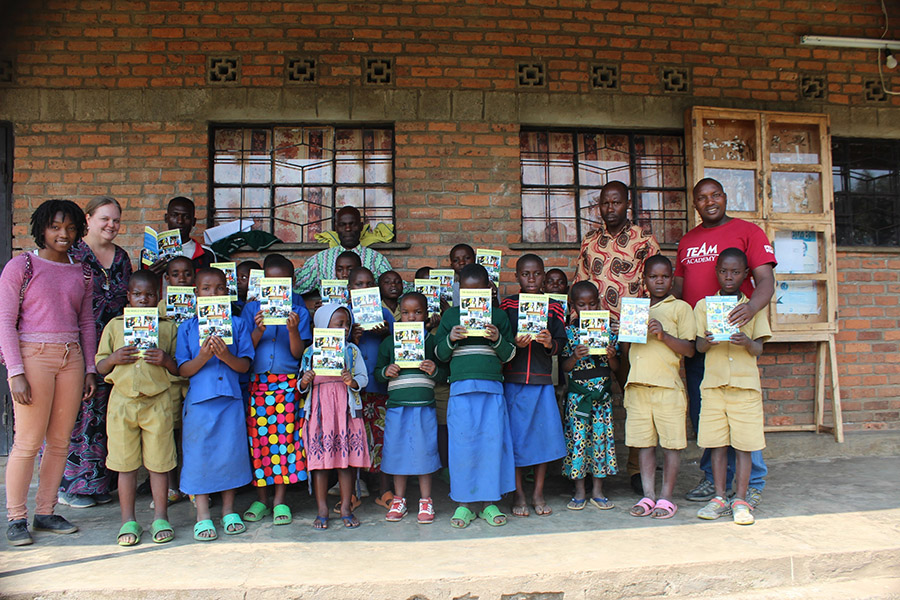 A group of African children holding new books.