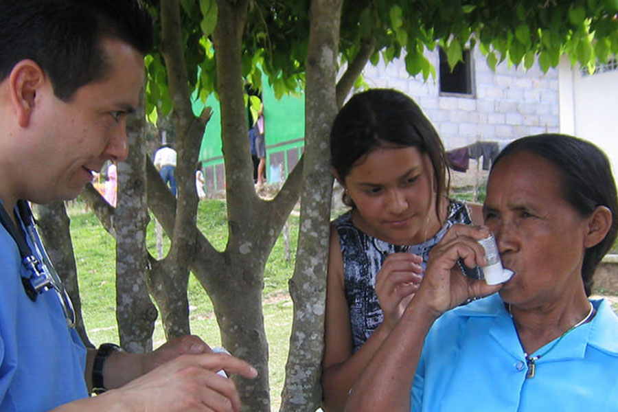 A doctor educates a Kenyan woman on using an inhaler.