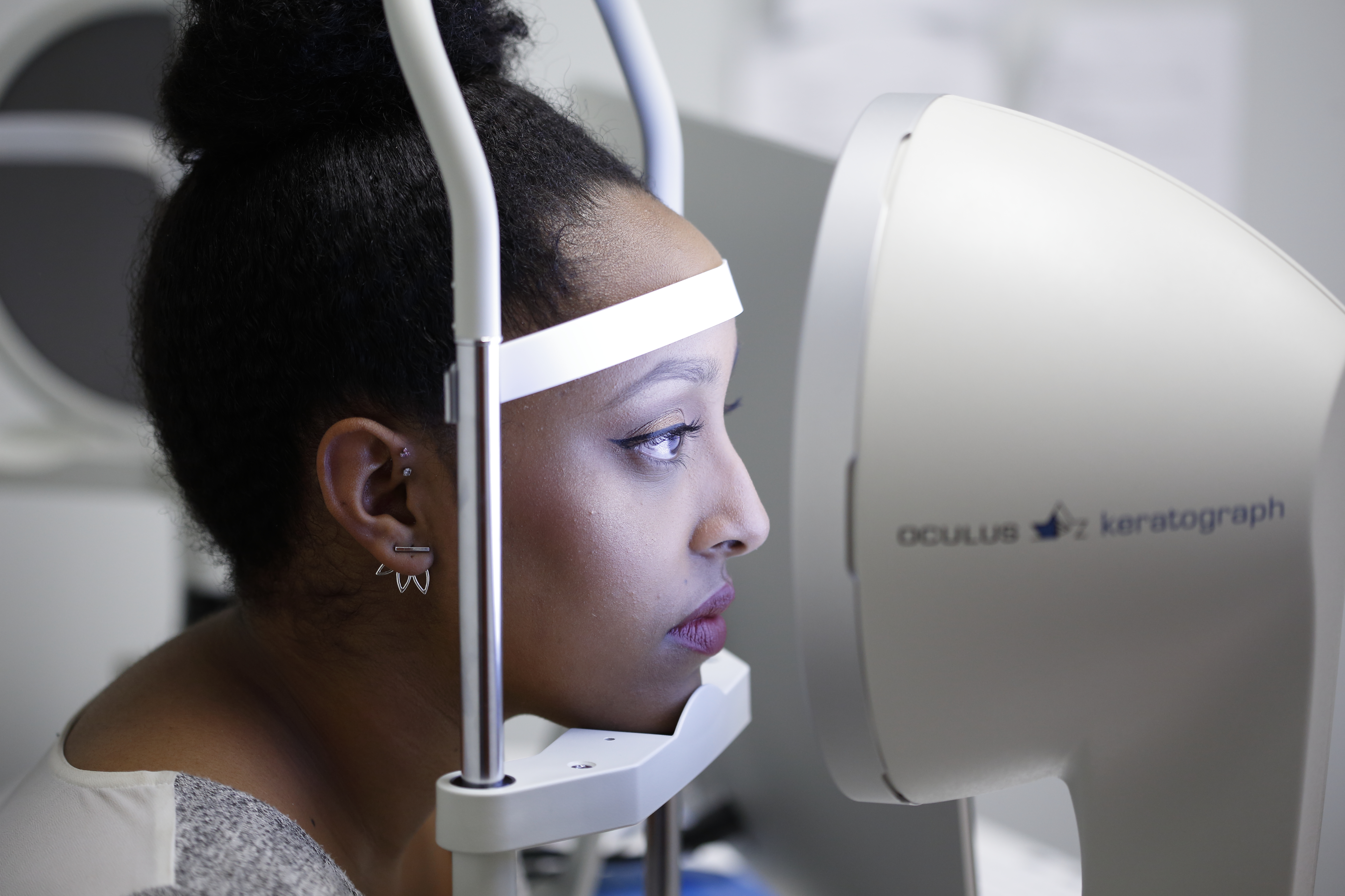 Woman looking into an ocular diagnostic machine.