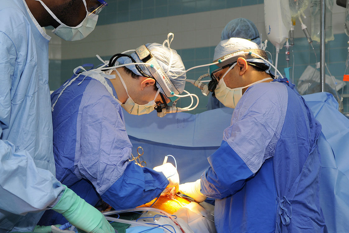 Surgeons performing a transplant in an operating room.