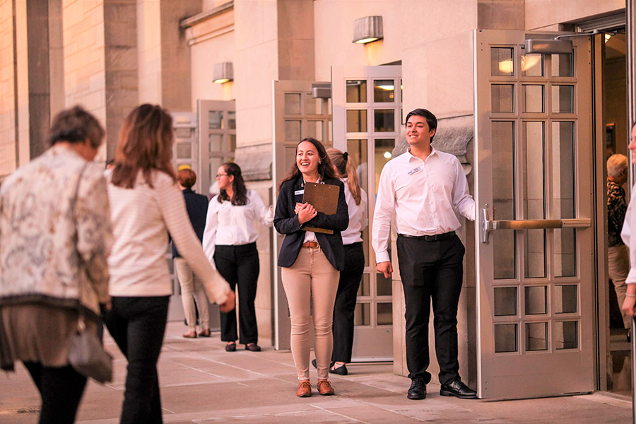 Ushers welcome guests at the entrance of the IU Auditorium.