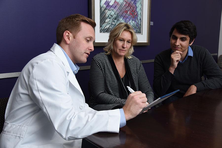 A psychiatrist goes over notes with patients.