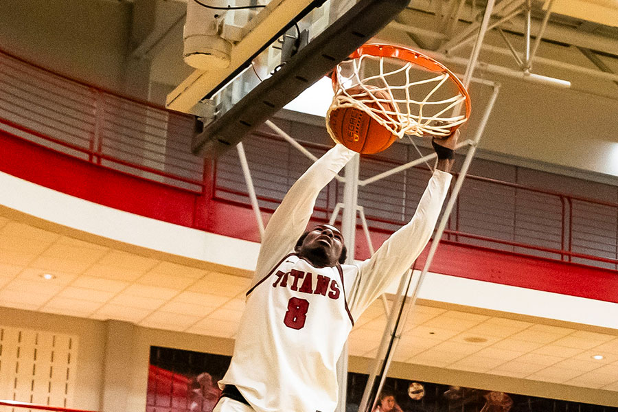 A men's basketball player dunks and scores.