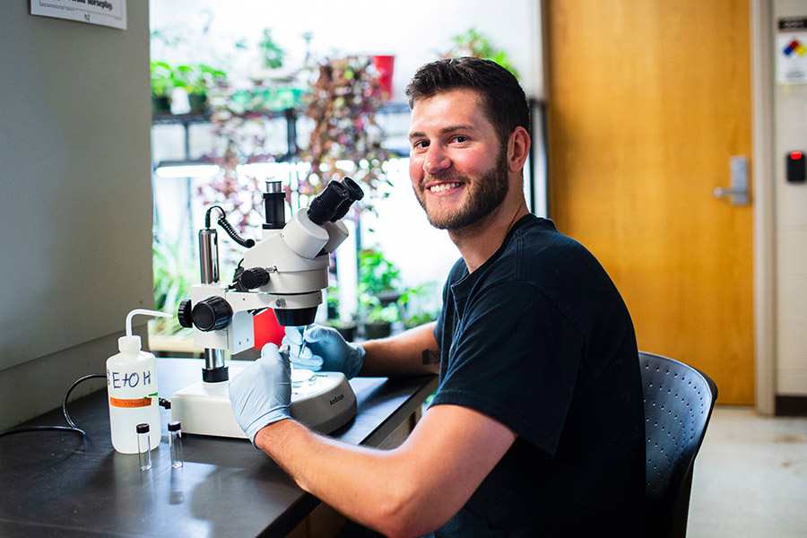 An IU student with a microscope.